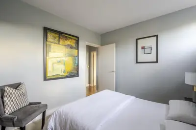 a bedroom with a white bed and a chair at Luxurious Private One Bedroom Apartment with Sky TV, Movies & Netflix in Braintree