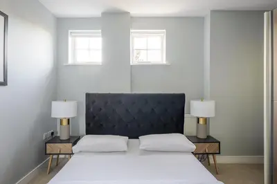 a bedroom with a large bed with two lamps at Luxurious Private One Bedroom Apartment with Sky TV, Movies & Netflix in Braintree