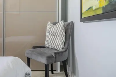 a chair with a pillow on it in a bedroom at Luxurious Private One Bedroom Apartment with Sky TV, Movies & Netflix in Braintree