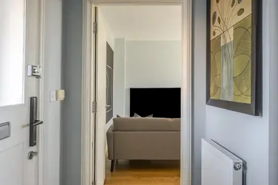 a door leading into a living room with a couch at Luxurious Private One Bedroom Apartment with Sky TV, Movies & Netflix in Braintree