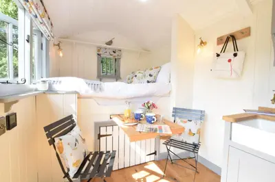 a tiny house with a bed and two chairs at Shepherds Pightle in Hollesley
