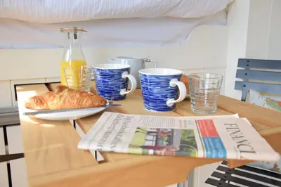a table with a newspaper and coffee cups and a magazine at Shepherds Pightle in Hollesley