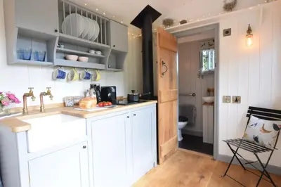 a kitchen with white cabinets and a sink at Shepherds Pightle in Hollesley