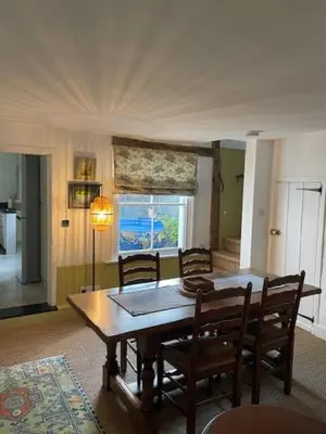 a dining room with a wooden table and chairs at Blythe Cottage in Long Melford