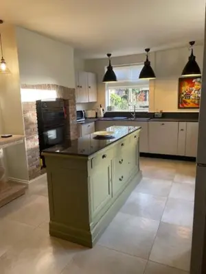 a kitchen with an island in the middle of a room at Blythe Cottage in Long Melford