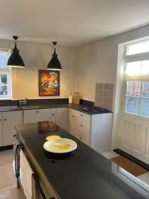 a kitchen with a black counter top in a room at Blythe Cottage in Long Melford