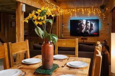 a wooden table with a vase with sunflowers on it at Spacious Cabin EVCharger and free Parking near Cambridge in Cambridge