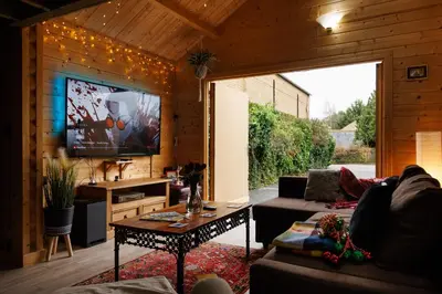 a living room with a couch and a tv at Spacious Cabin EVCharger and free Parking near Cambridge in Cambridge