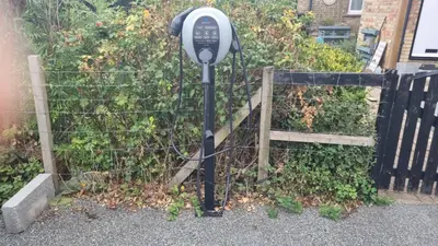 a parking meter in front of a fence at Spacious Cabin EVCharger and free Parking near Cambridge in Cambridge