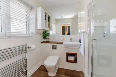 a white bathroom with a toilet and a sink at My Chester Luxury Home in Colchester