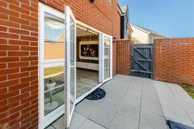 a patio with sliding doors in a brick building at My Chester Luxury Home in Colchester