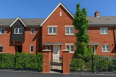 a brick house with a fence in front of it at My Chester Luxury Home in Colchester