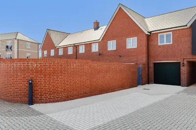 a red brick building with a gate and a garage at My Chester Luxury Home in Colchester