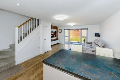 an open kitchen and living room with a staircase at My Chester Luxury Home in Colchester