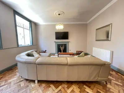 a living room with a couch and a fireplace at Cathedral View Apartment, Flat 4 in Bury Saint Edmunds