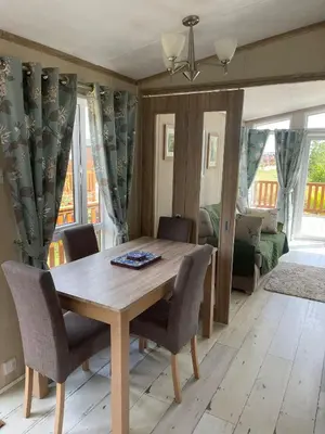a dining room with a wooden table and chairs at Fern Lodge with Hot Tub in Stonham Aspall