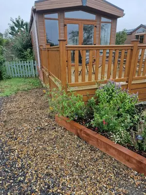 a garden with a wooden fence and some plants at Fern Lodge with Hot Tub in Stonham Aspall