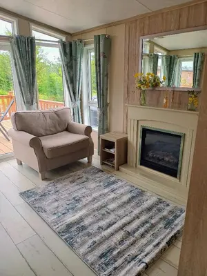 a living room with a couch and a fireplace at Fern Lodge with Hot Tub in Stonham Aspall