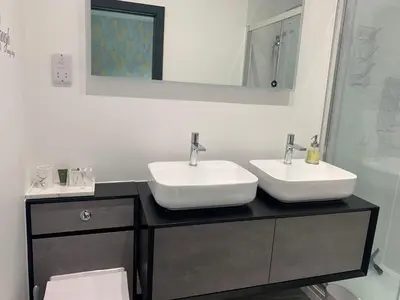 a bathroom with two sinks on a black counter at Belvedare-Suffolk in Sudbury
