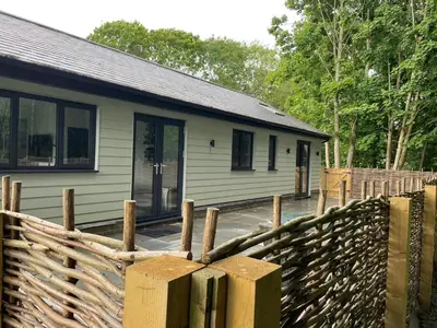 a house with a wooden fence in front of it at Belvedare-Suffolk in Sudbury