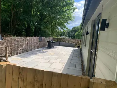 a patio next to a building with a fence at Belvedare-Suffolk in Sudbury