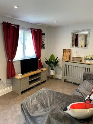 a living room with a bed and a television at Belvedare-Suffolk in Sudbury