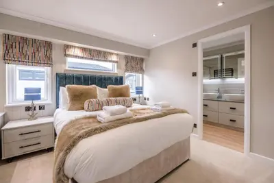 a bedroom with a large bed and a bathroom at Briargate, Aldeburgh in Aldeburgh