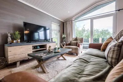 a living room with a couch and a tv at Briargate, Aldeburgh in Aldeburgh