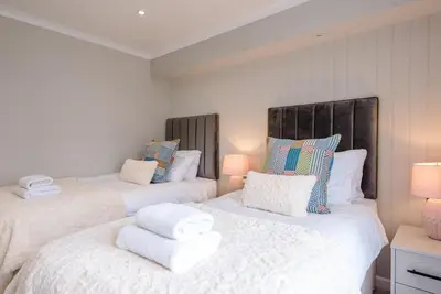 two beds in a room with white sheets and pillows at Briargate, Aldeburgh in Aldeburgh