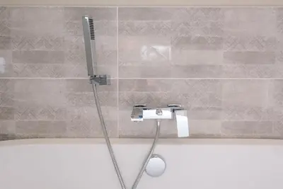 a shower in a bathroom with a shower head at Marshwiggle, Aldeburgh in Aldeburgh