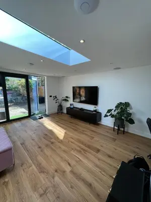 a living room with a flat screen tv on the wall at Modern Studio with parking in shared garden in Theydon Bois