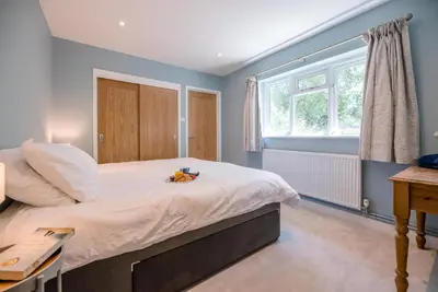 a bedroom with a large bed and a window at Ferry Corner Cottage, Sudbourne in Woodbridge