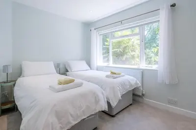 two beds in a bedroom with a window at Ferry Corner Cottage, Sudbourne in Woodbridge