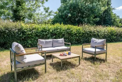 three chairs and a coffee table in the grass at Ferry Corner Cottage, Sudbourne in Woodbridge