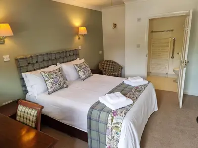 a bedroom with a bed and a chair and a table at The Courthouse Inn in Colchester