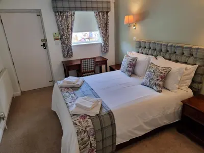 a bedroom with a large bed with white sheets and pillows at The Courthouse Inn in Colchester