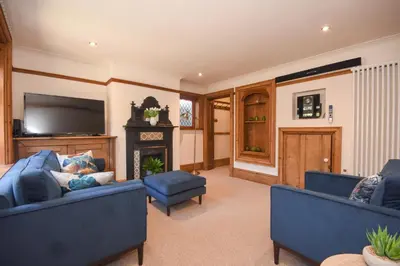 a living room with two blue couches and a fireplace at Unique period one bedroom house in Colchester in Colchester