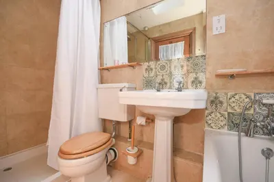 a bathroom with a toilet and a sink and a mirror at Unique period one bedroom house in Colchester in Colchester