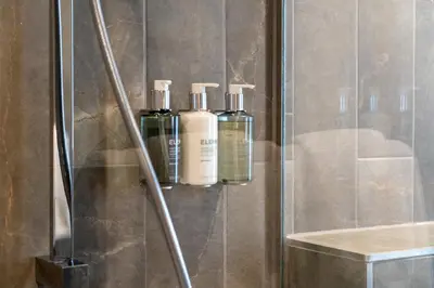 three bottles ofodorizers sit on a shelf in a shower at The Pier Hotel in Harwich
