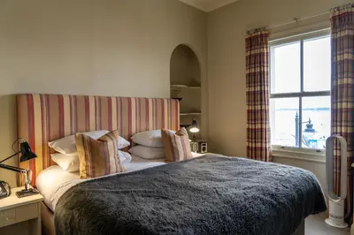 a bedroom with a large bed and a window at The Pier Hotel in Harwich