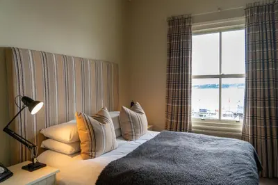 a bedroom with a bed with pillows and a window at The Pier Hotel in Harwich