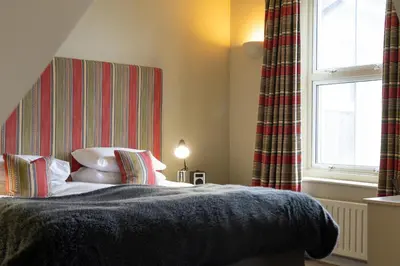 a bedroom with a bed and a window at The Pier Hotel in Harwich