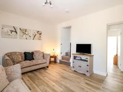 a living room with a couch and a tv at Lily Cottage in Downham Market