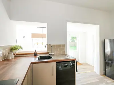 a kitchen with a sink and a black refrigerator at Lily Cottage in Downham Market