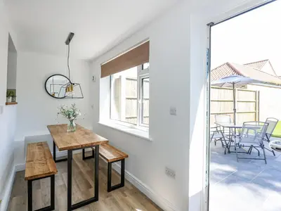 a dining room with a table and a window at Lily Cottage in Downham Market