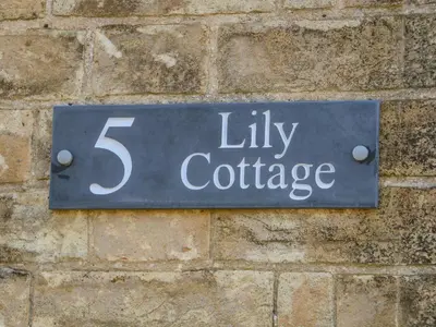 a sign on a brick wall that reads lift cottage at Lily Cottage in Downham Market