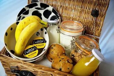 a basket with bananas and cookies and jars of milk at The Woolpack Inn in Coggeshall