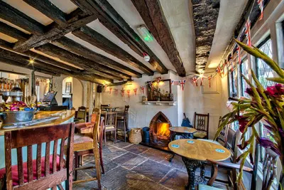 a restaurant with a fireplace and tables and chairs at The Woolpack Inn in Coggeshall