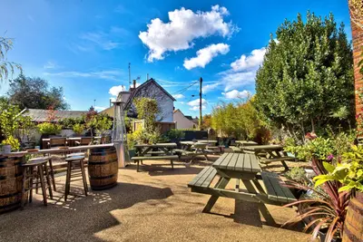 a group of picnic tables and chairs in a courtyard at The Woolpack Inn in Coggeshall