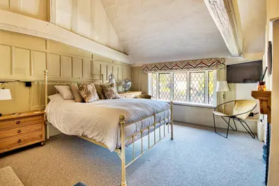 a bedroom with a large bed and a window at The Woolpack Inn in Coggeshall